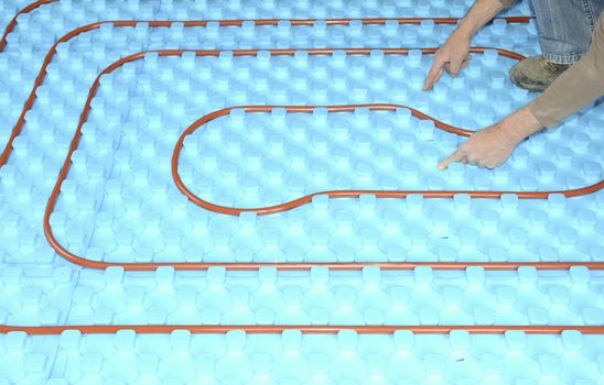 plumber installing a floor heating on insulation