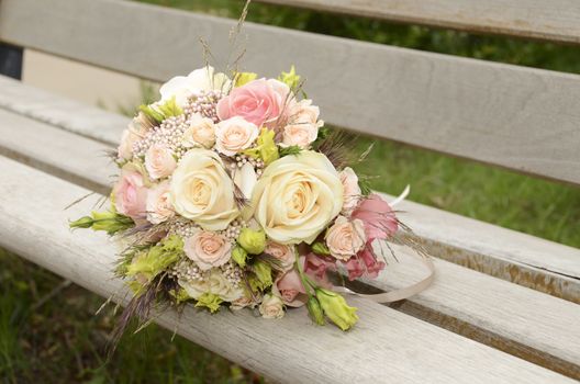 bouquet of wedding flowers lying on a wooden bench