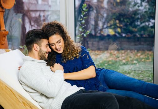 Young handsome couple relaxing at home and showing sweetest emotions.