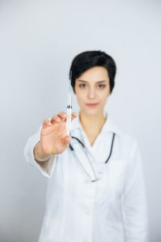 Female doctor with syringe, isolated on white background. Medicine and health care concept.