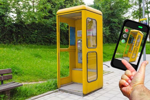 Telephone boxes have not yet served their time. Concept old technology against new.