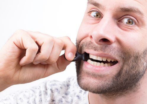 Man eating typicaly dutch candy called 'Dropsleutel' (candy key) - Isolated