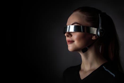 Woman using futuristic VR goggles headset with microphone