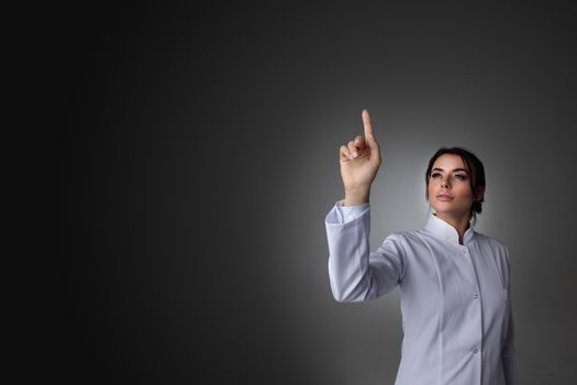 Female scientist or doctor pointing to futuristic display