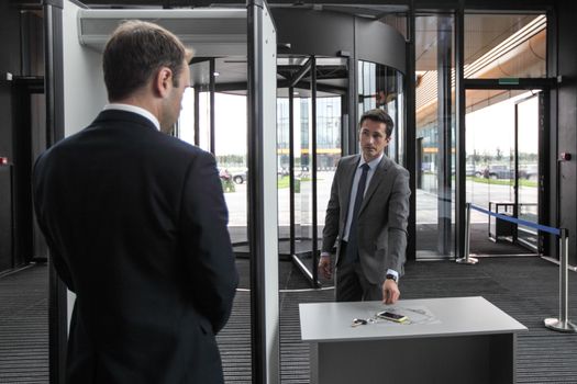 Man at airport security gates putting out phone and keys