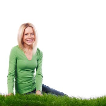 Young beautiful woman sitting on grass, isolated on white background