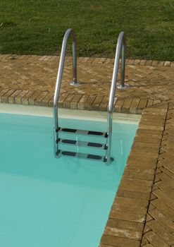 swimming pool with stairs and grass field