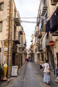 Cefalu,Sicile,Europe-05/06/2018.View of a shopping street in Cefalu with old town in background in northern Sicily in Italy