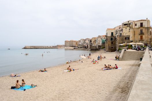 View of the beach of Cefalu with the old city in the background in the north of Sicily in Italy