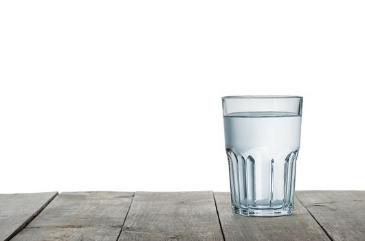 Glass of water on wooden table isolated on white background