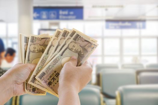 Yen Banknotes In Hand That Are Ready For Travel Tourism On Blurred Background, Tourist Business Idea