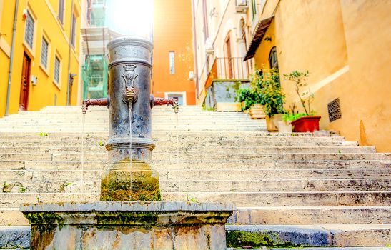 old cast iron fountain in front of an ancient staircase in Rome, Italy