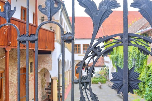 View on romantic urban scenery through forged banister. Historic urban backyard.