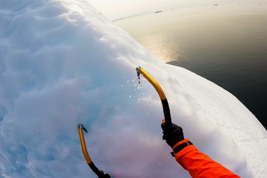 Hooks climber on the glacier. The climber climbs the glacier.