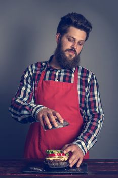 Man cooking fresh self made black burger close up