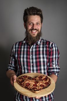 Happy smiling man gives burned heart shapes pizza