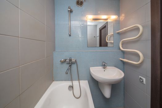 Small grey tile bathroom with bath tube and sink