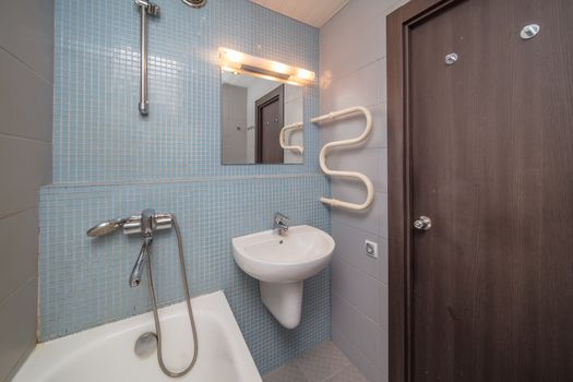 Small grey tile bathroom with bath tube and sink