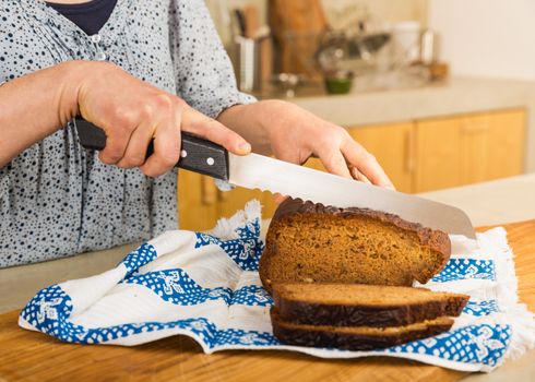 Woman cutting slices of gluten-free bread 