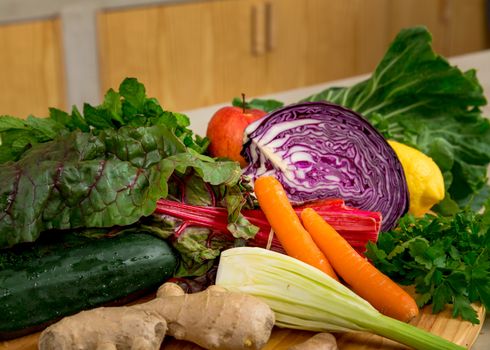 Several vegetables on top of a wooden board. Ingredients for detox diet. 