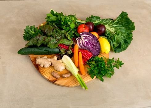 Several vegetables on top of a wooden board. Ingredients for detox diet. 