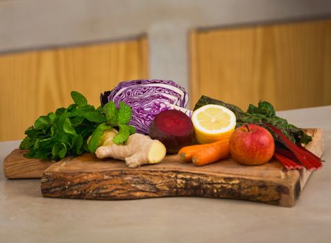 Several vegetables on top of a wooden board. Ingredients for detox juice.
