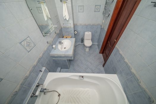 Small blue tile bathroom with bath tube and sink
