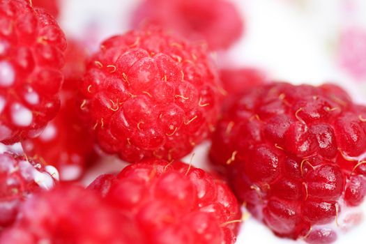 A background of ripe red raspberry with milk