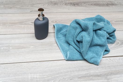 liquid soap dispenser and a towel on a wooden table