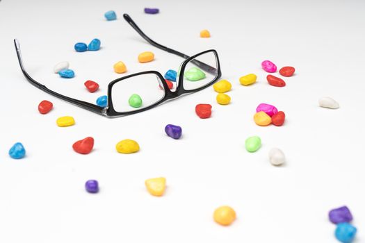 a pair of glasses between small colored stones