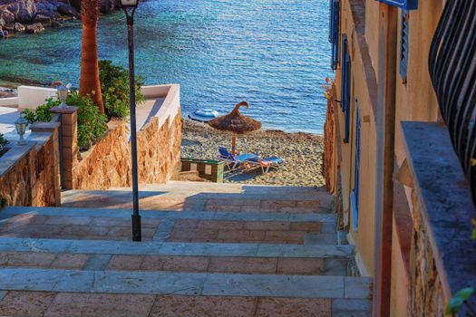 Stairs to the beach in the background two empty sunbeds