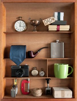 Fathers day gift with label inside a shelving unit with various objects including tools, camera and coffee cup