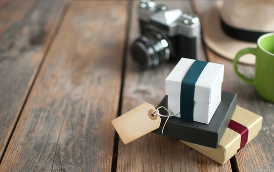 Gifts with blank label on a wooden background