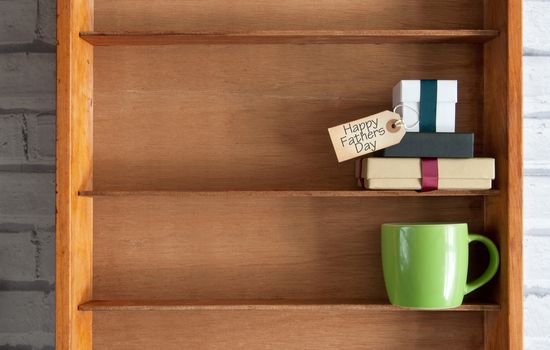 Fathers day gifts with greeting label inside a shelf unit with coffee cup