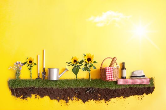 Summer picnic basket on grass patch with sunflowers