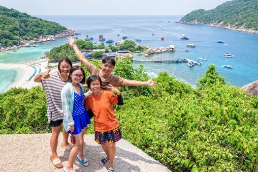 Thai family tourists is posing happily on top of the Koh Nang Yuan island is a high viewpoint and beautiful natural landscape is a famous attractions in the Gulf of Thailand, Surat Thani, Thailand