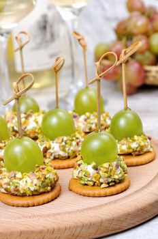 Canape  of cottage cheese cushions  in pistachios with grapes on cracker