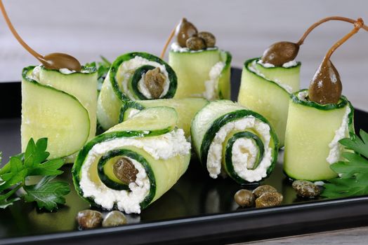 Cucumber rolls with ricotta filling and capers.   These rolls with the size of a bite -is a great option with a low fat content, which serves as a snack.
