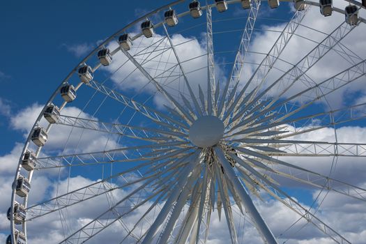 The Ferris wheel with the closed cabs has stopped that new passengers could take places