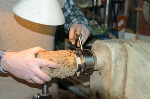 The turner fixes the wooden part in the lathe