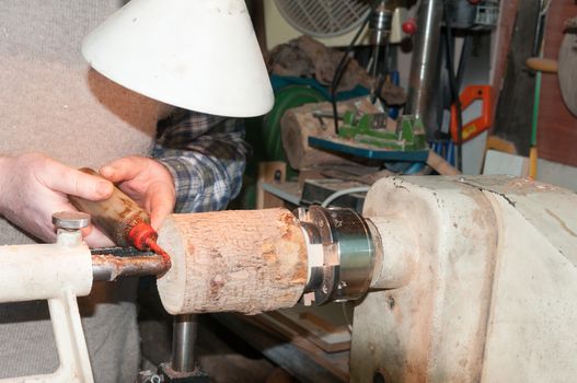 The worker greases the cone for a better slip of the wooden details clamped in the lathe