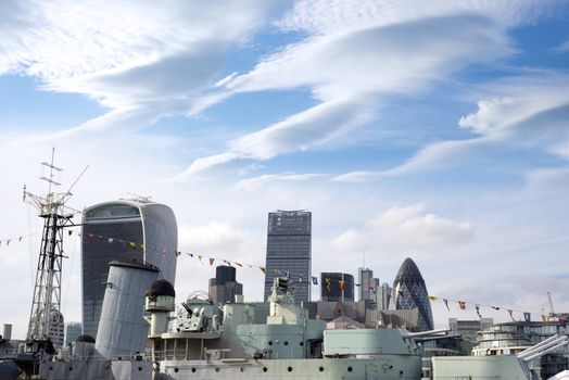 hms belfast docked at the city of london with skyscrapers in the background