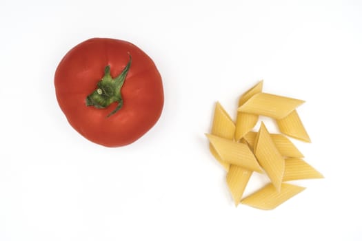 a tomato and pasta on a white table