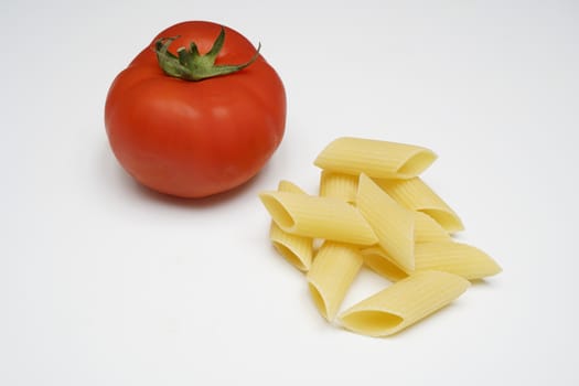 a tomato and pasta on a white table