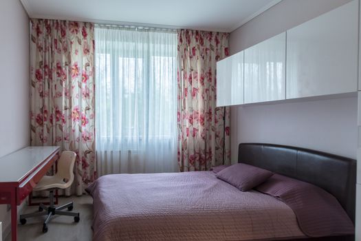 Simple bedroom with window and cupboard in daylight