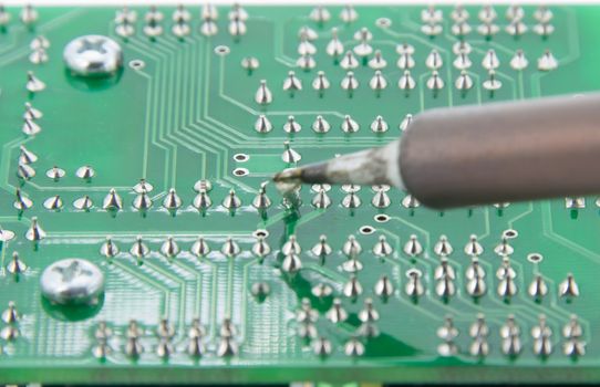 The Solder electronics PCB with the soldering iron