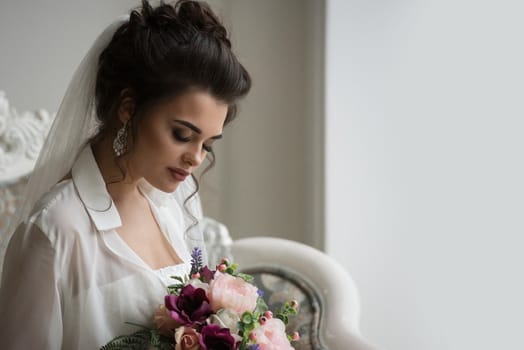 Beautiful bride posing in her wedding day with flower bouquet