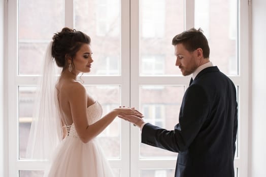 Young married couple holding hands, ceremony wedding day