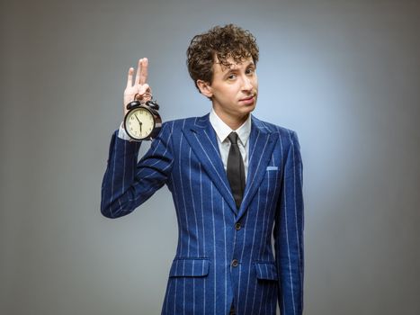 Funny businessman holding alarm clock showing time of deadline