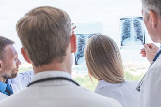 Group of doctors look and discuss x-ray in a clinic or hospital